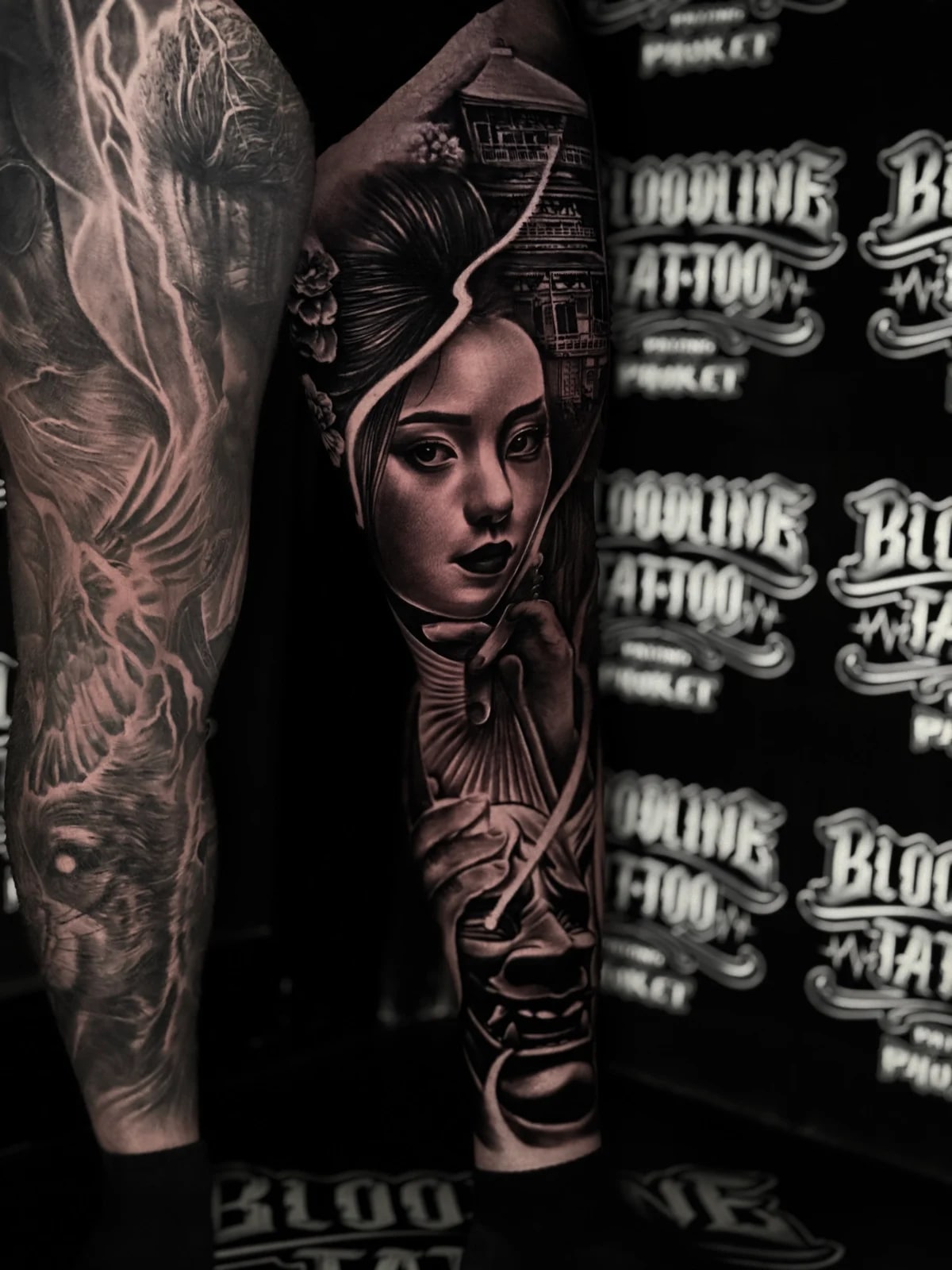 Japanese black and grey full leg tattoo with woman's portrait, pagoda, folding fan, Hannya mask, and lightning-like highlights at Bloodline Tattoo Phuket.