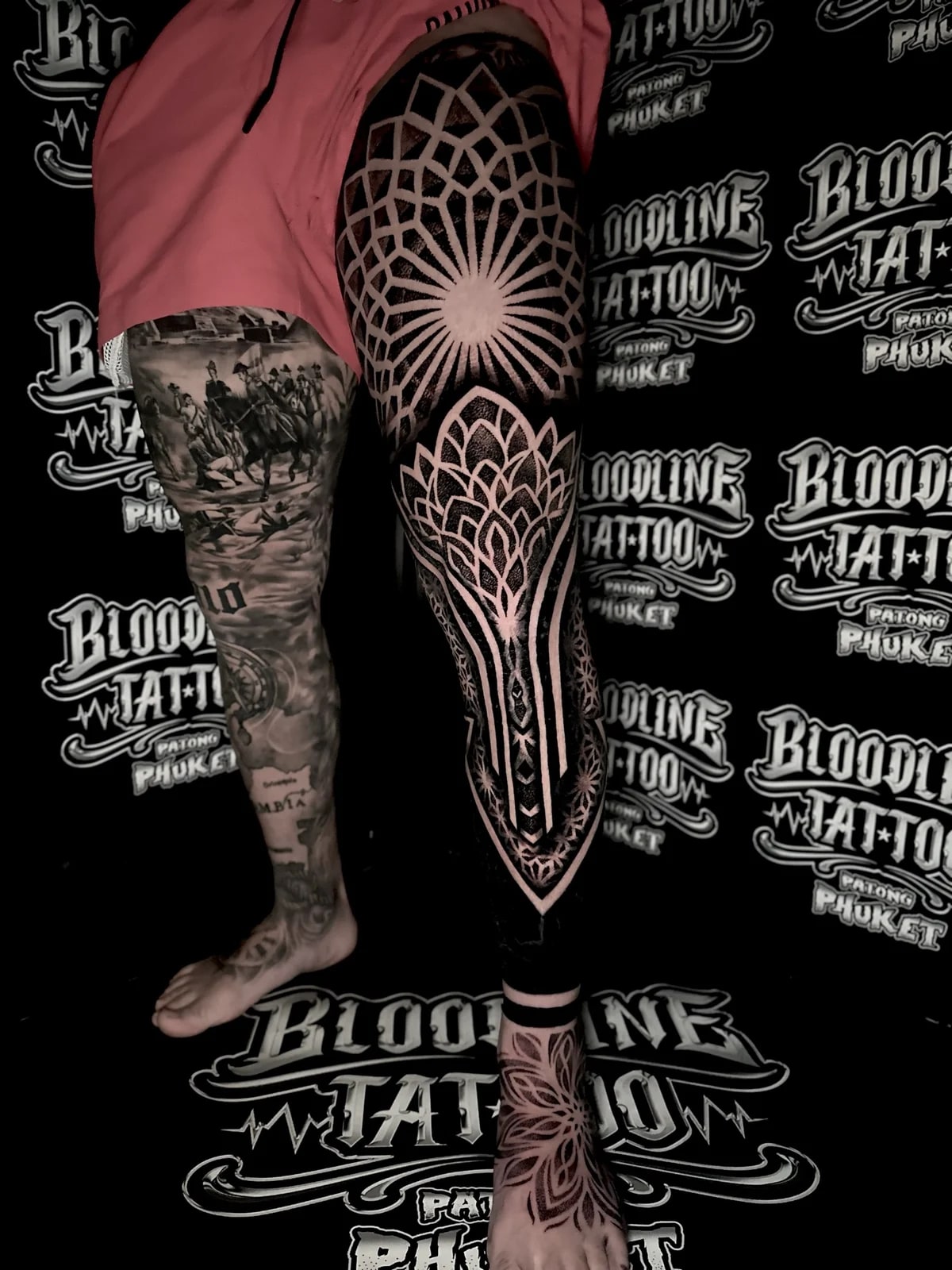 Full leg mandala blackwork with a radiating knee mandala, pointed lotus panels, geometric shin bands, and a foot mandala at Bloodline Tattoo Phuket.