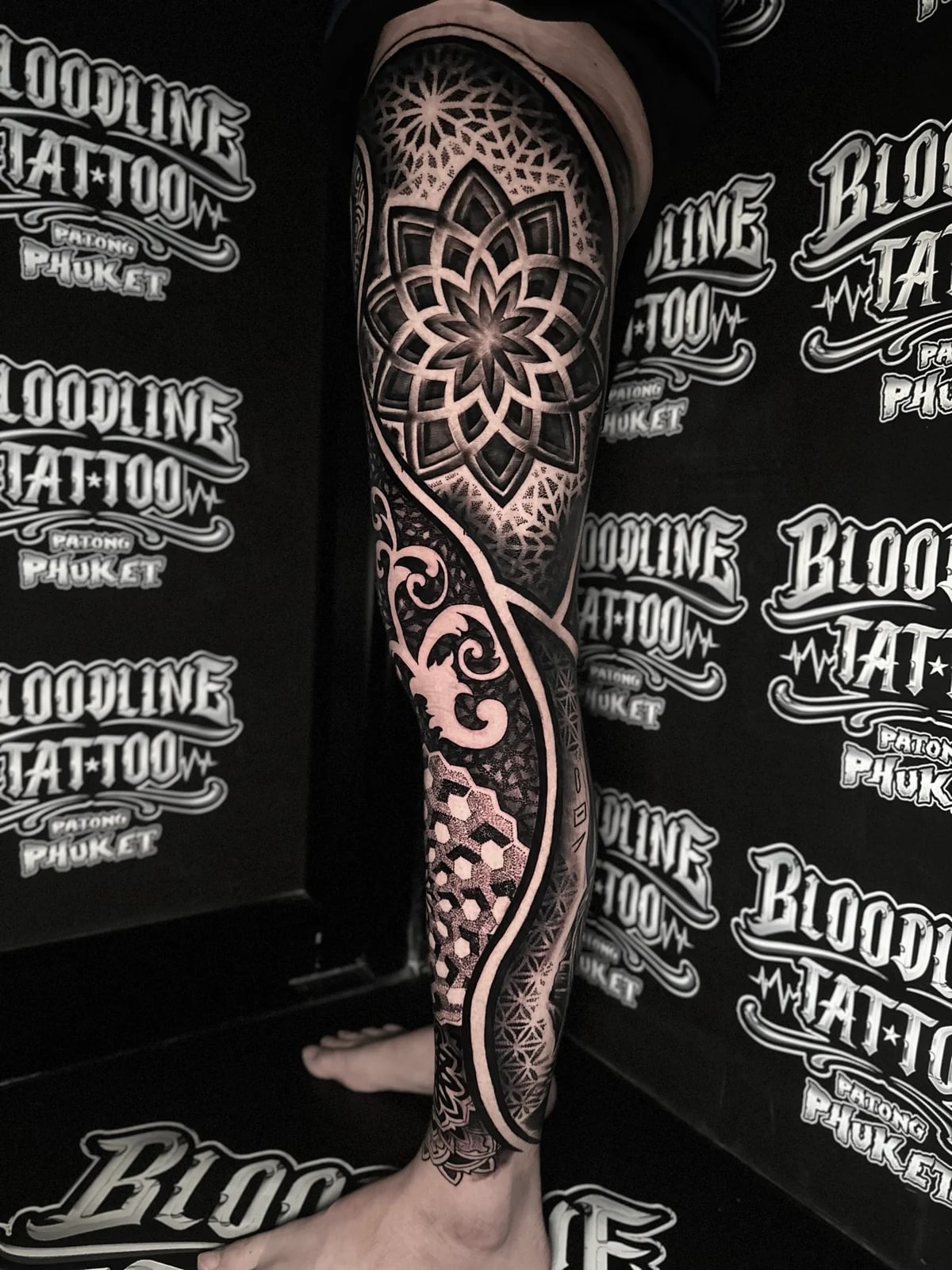 Full leg mandala sleeve with a thigh lotus mandala, ornamental scrollwork, 3D cube calf geometry, and Flower of Life ankle patterns at Bloodline Tattoo Phuket.