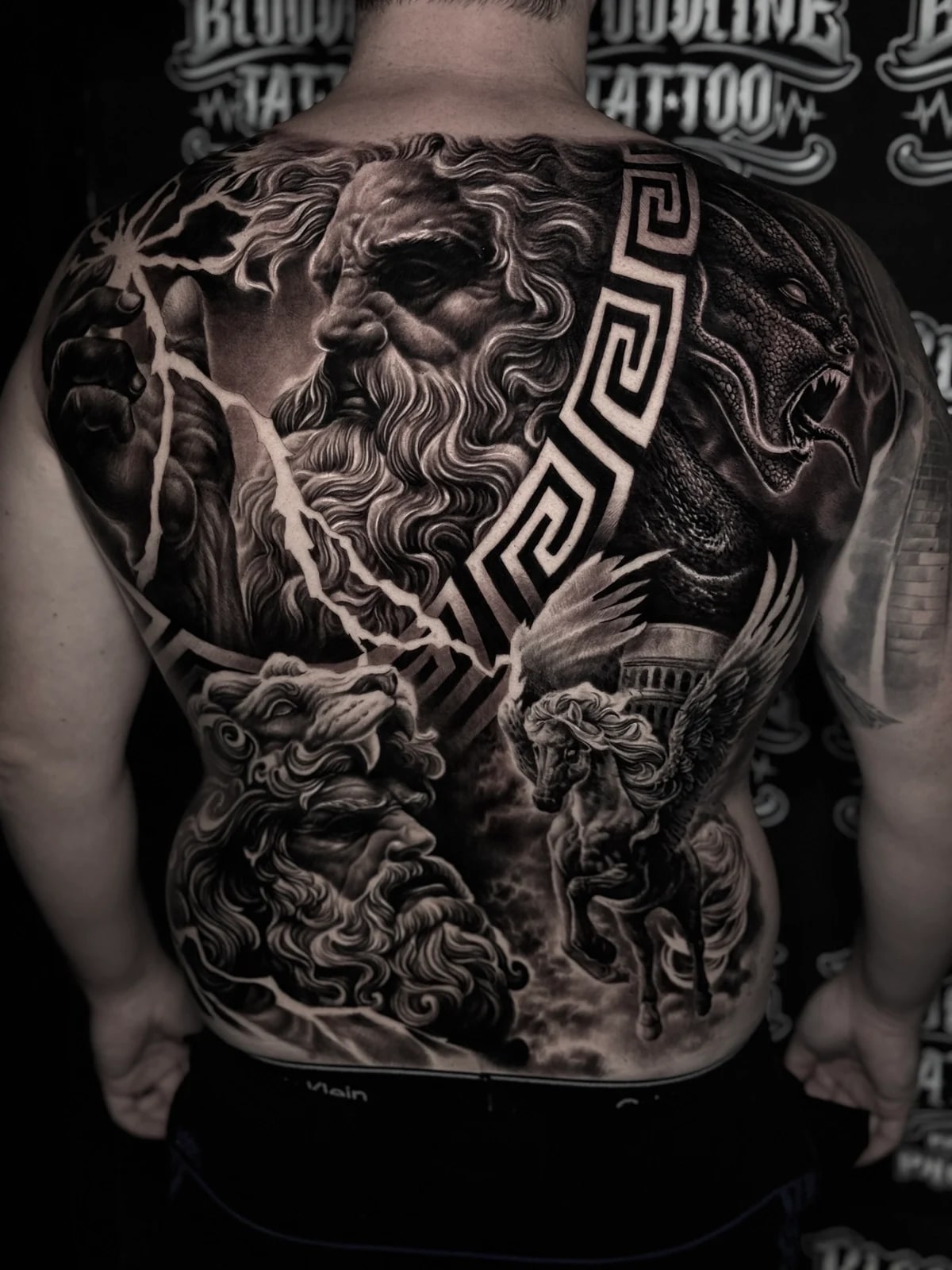 Detailed black and grey realism full back tattoo featuring Zeus with lightning, serpent creature, Hercules in lion pelt, Pegasus, and Greek key band at Bloodline Tattoo Phuket.
