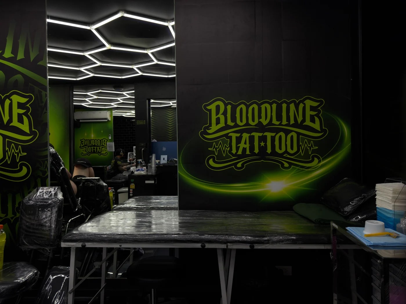 Bloodline Tattoo Phuket branding wall with clean workstation and preparation area