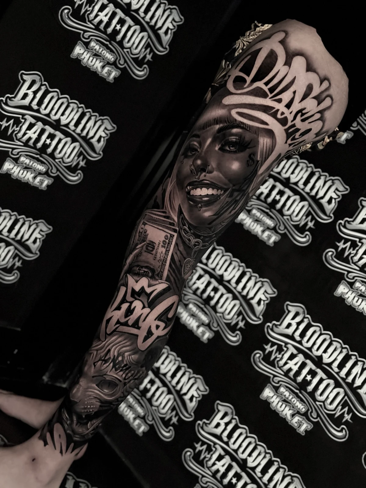 Chicano King and Amor script leg sleeve with cash stack and tiger portrait at Bloodline Tattoo Phuket.