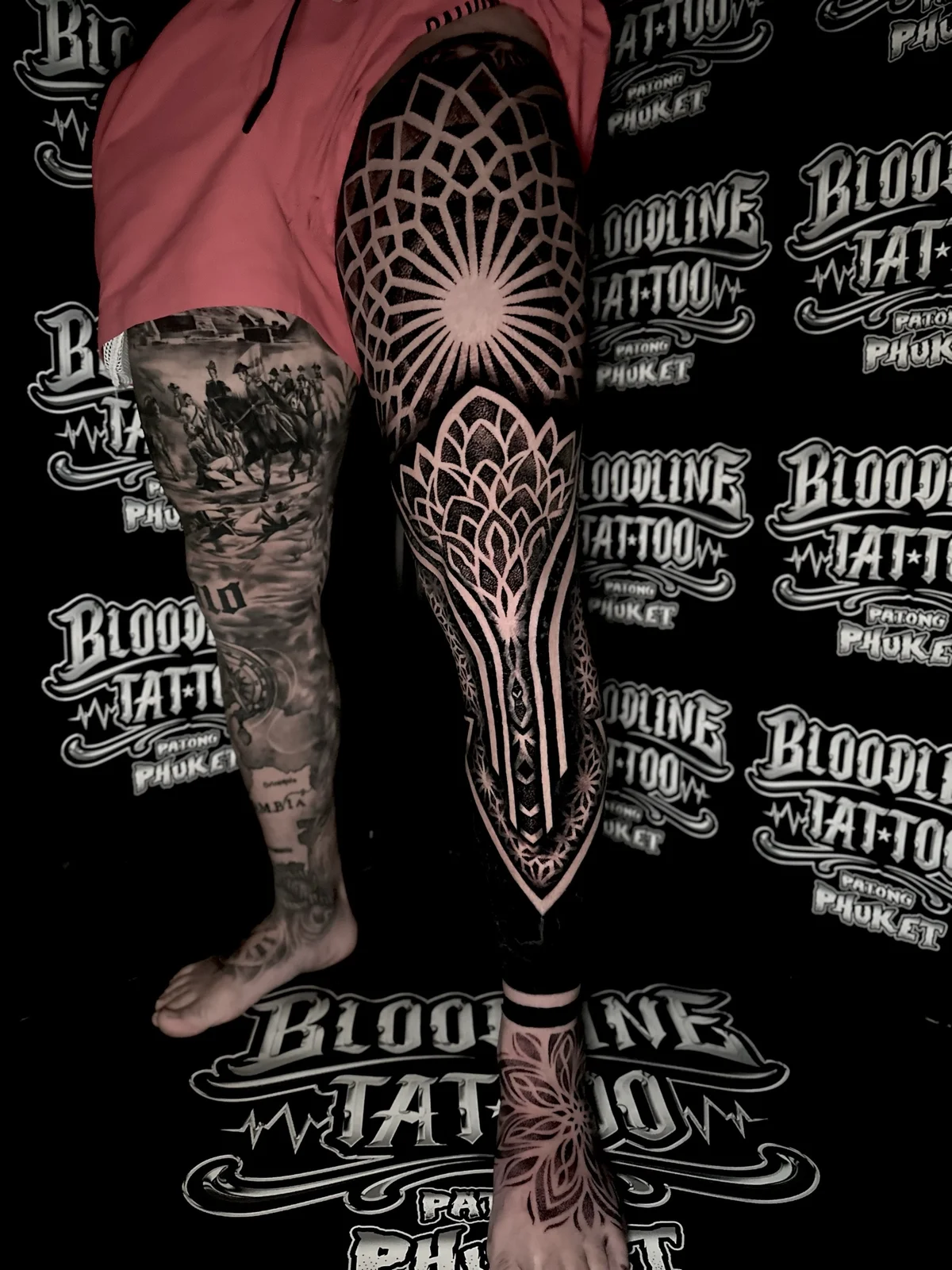 Full leg mandala blackwork with a radiating knee mandala, pointed lotus panels, geometric shin bands, and a foot mandala at Bloodline Tattoo Phuket.